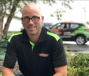 Male employee John Alessio in front of SERVPRO car